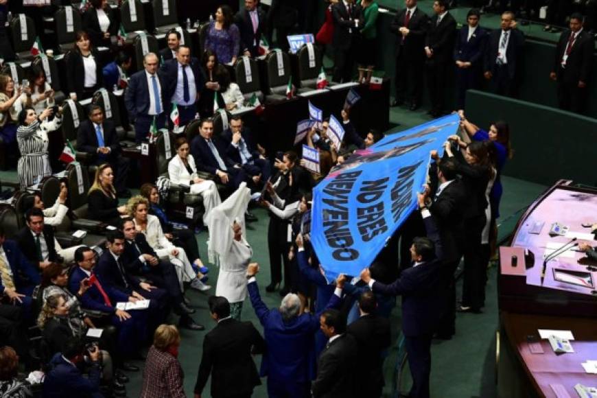 Los diputados mexicanos del Partido de Acción Nacional (PAN) sostienen un cartel que dice 'Maduro, no son bienvenidos' en el Congreso de la Unión, en la Ciudad de México, durante la ceremonia de inauguración del Presidente de México, Andrés Manuel López Obrador.