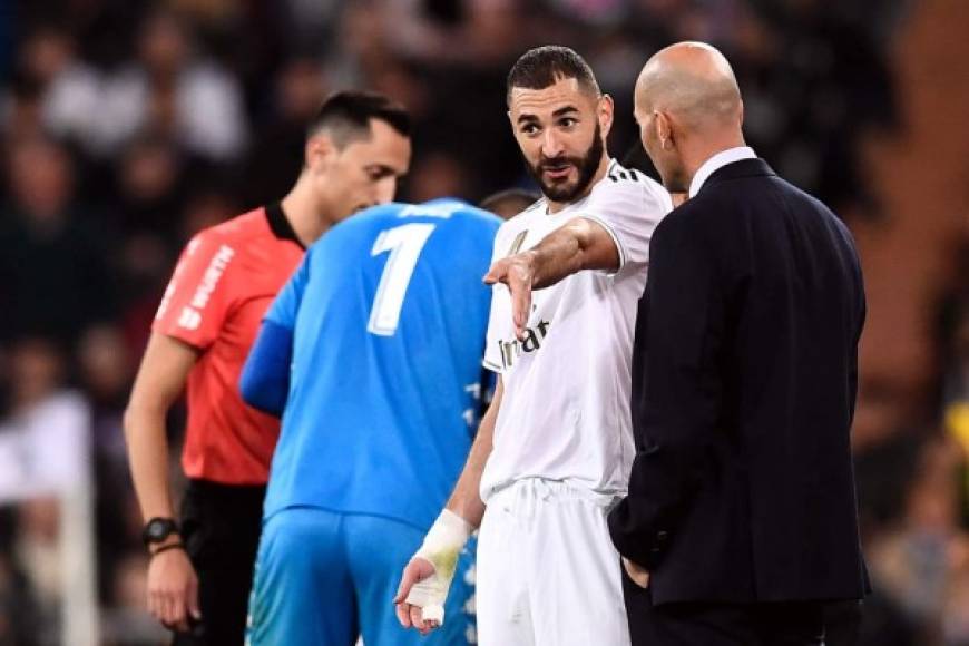 Karim Benzema dialoga con su entrenador Zinedine Zidane en un momento del partido.