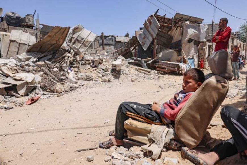 Ciudadanos palestinos inspeccionan su casa, después de que fuera destruida por un ataque aéreo israelí, en la ciudad de Rafah, en el sur de la Franja de Gaza el 16 de mayo de 2021. (Foto de SAID KHATIB / AFP)