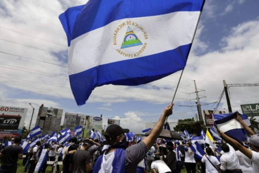 '¡Ni un paso atrás!', '¡Justicia!', '¡Qué se vaya!', coreó la multitud azul y blanco, que caminó en calma 7 km por estratégicas vías del sureste de la capital, sin que la luvia que cayó durante un rato los ahuyentara.