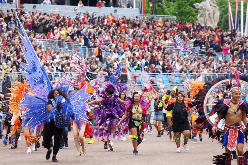A este desfile se sumaron también miles de voluntarios que representaron, con diversos disfraces, los momentos más importantes de las siete décadas del reinado de Isabel II.
