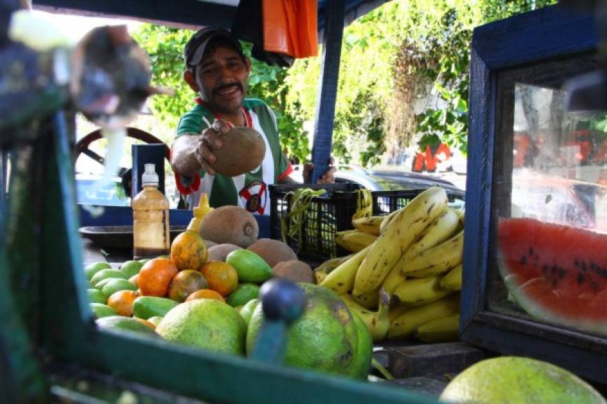 Un vendedor de frutas ofreciendo mangos, mandarinas, zapotes, piña, naranjas y otras delicias tropicales del país.