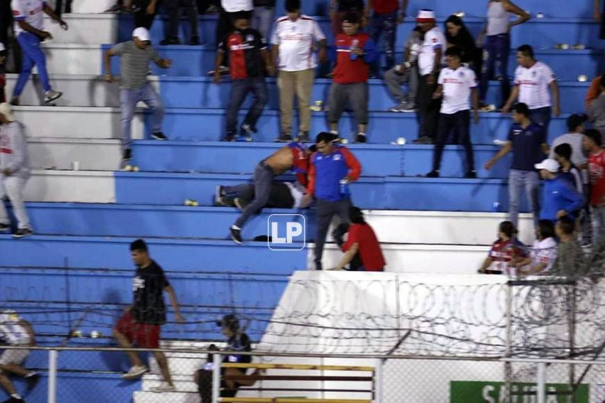 Estos dos aficionados del Olimpia se fueron a los golpes en plena disputa del partido.