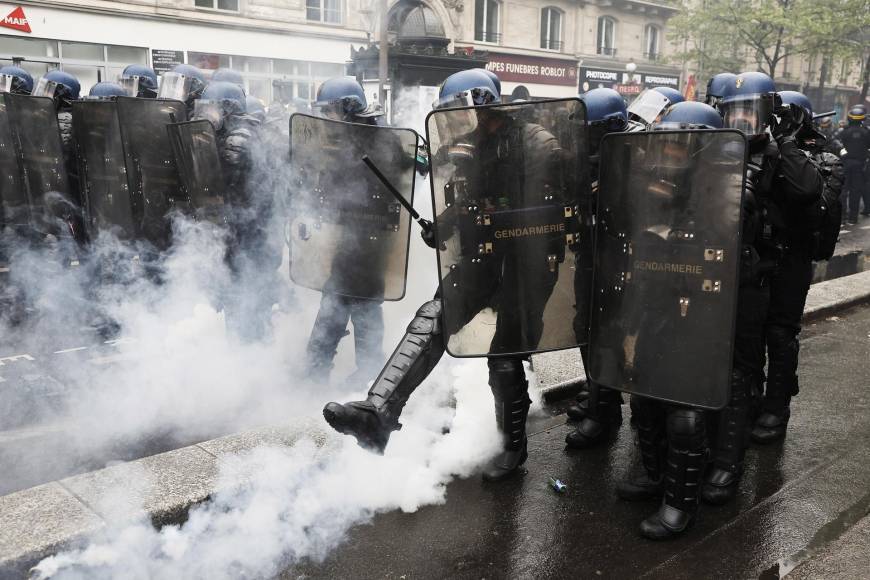 Paris (France), 01/05/2023.- A riot police kicks a tear gas canister during clashes at the annual May Day march in Paris, France, 01 May 2023. Despite the Constitutional Council's adoption of the law on 14 April raising the retirement age in France from 62 to 64 years old, protests against pension reform are being held in France on this International Workers' Day. Following the filing of a new appeal by the left-wing senators, a new decision is expected on 03 May. (Protestas, Francia) EFE/EPA/CHRISTOPHE PETIT TESSON 
