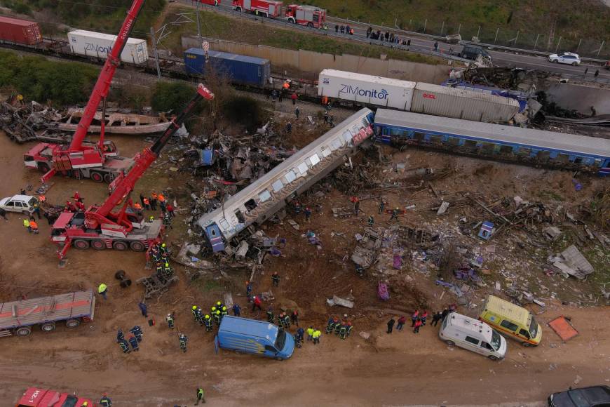 This aerial drone photograph taken on March 1, 2023, shows emergency crews examining the wreckage after a train accident in the Tempi Valley near Larissa, Greece. - At least 32 people were killed and another 85 injured after a collision between two trains caused a derailment near the Greek city of Larissa late at night on February 28, 2023, authorities said. A fire services spokesman confirmed that three carriages skipped the tracks just before midnight after the trains -- one for freight and the other carrying 350 passengers –- collided about halfway along the route between Athens and Thessaloniki. (Photo by STRINGER / AFP)