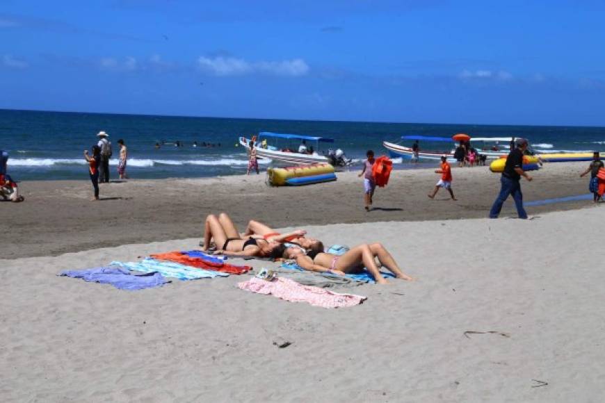 Hermosas mujeres disfrutan del sol, la playa y la arena en Tela.
