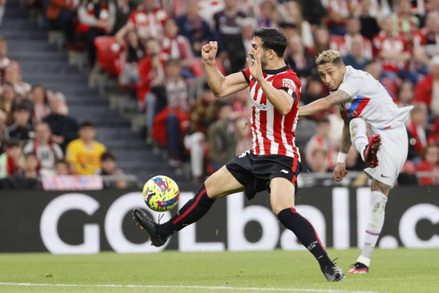 El delantero brasileño Raphinha remata ante el defensa del Athletic Club de Bilbao, Mikel Balenciaga, para marcar el primer gol del Barcelona.