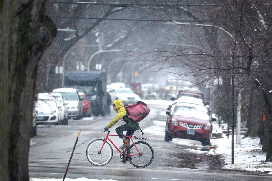 CHICAGO, ILLINOIS - JANUARY 25: A cyclist rides his bike as snow falls in the Humboldt Park neighborhood on January 25, 2023 in Chicago, Illinois. A little more than 3 inches of wet snow fell on the city as a weather system moved across the nation dropping snow and wreaking havoc on travel from St. Louis to Boston. Scott Olson/Getty Images/AFP (Photo by SCOTT OLSON / GETTY IMAGES NORTH AMERICA / Getty Images via AFP)