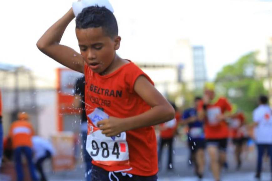 Un pequeño refrescándose mientras realiza su recorrido en la Maratón.