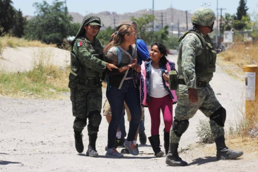 Members of Mexican National Guard detain Central American migrants trying to cross the Rio Bravo, in Ciudad Juarez, State of Chihuahua, on June 21, 2019. - Mexican President Andres Manuel Lopez Obrador suggested Friday he and US counterpart Donald Trump should hold their first meeting in September to review progress on the countries' recent migration deal. (Photo by HERIKA MARTINEZ / AFP)