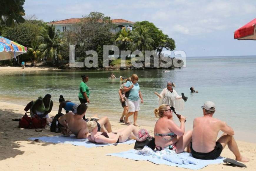 Turistas disfrutando del sol, la arena y el mar.