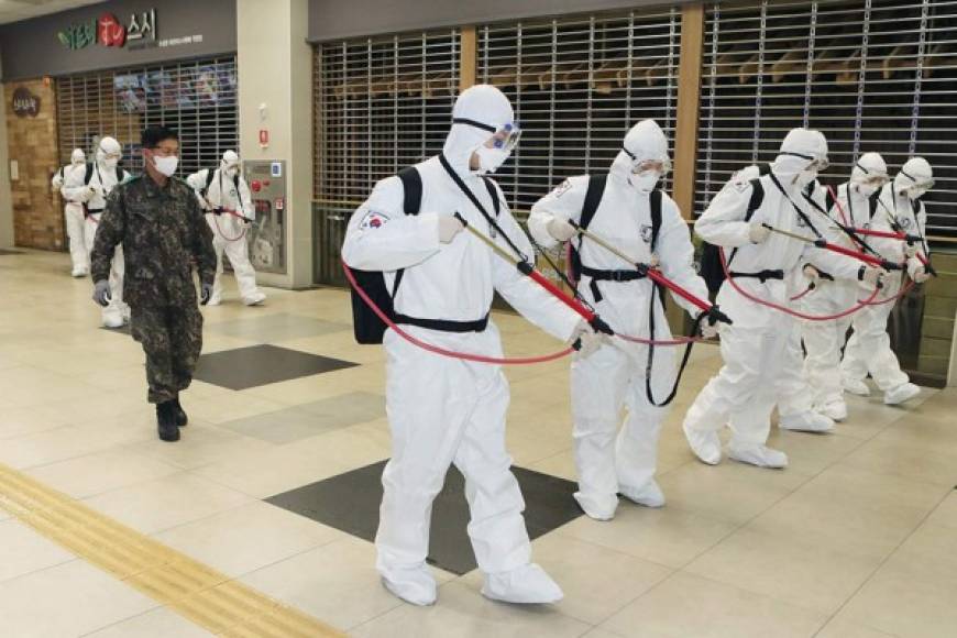 Soldados surcoreanos que usan desinfectante protector en aerosol como parte de las medidas preventivas contra la propagación del coronavirus COVID-19, en un centro comercial de la estación de ferrocarril de Dongdaegu en Daegu el 29 de febrero de 2020.