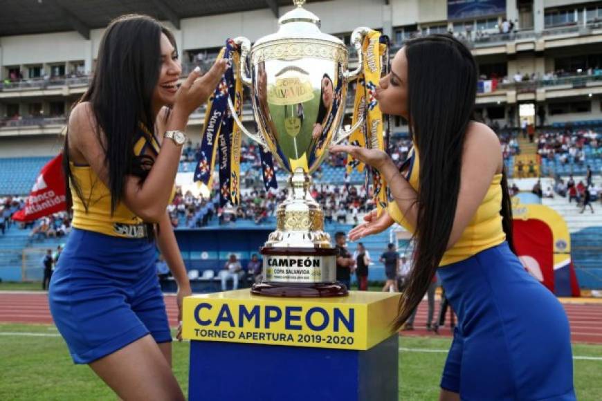 La Copa que obtendrá el campeón del Torneo Apertura 2019, bien acompañada por dos bellas chicas.
