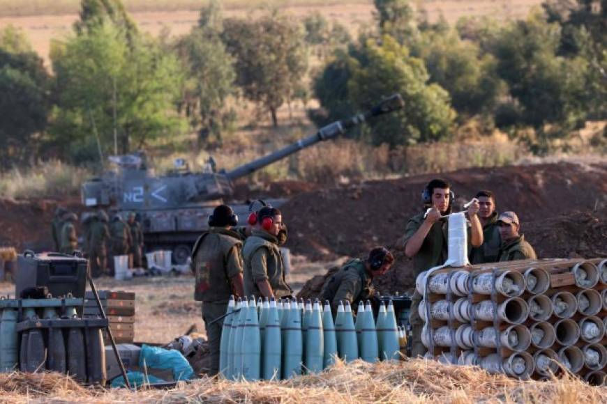 Israeli soldiers prepare a 155mm self-propelled shell to fire towards the Gaza Strip from their position near the southern Israeli city of Sderot on May 13, 2021. - Israel deployed additional troops to Gaza's border as the military conflict with Palestinian Islamists raged on, while inside Israel security forces scrambled to contain deadly riots between Jews and Arabs. Army tanks shelled the Palestinian enclave and AFP reporters saw troops assembling at the security barrier. But the armed forces maintained a ground offensive was not the primary focus of the operation against Palestinian militants. (Photo by EMMANUEL DUNAND / AFP)