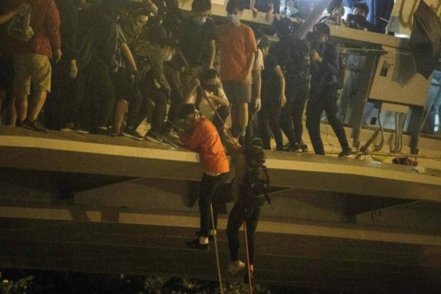 Cientos de universitarios sitiados por la policía en una universidad de Hong Kong lograron escapar el lunes por la noche, tras una nueva amenaza de intervención de China para resolver la crisis política en el territorio autónomo.