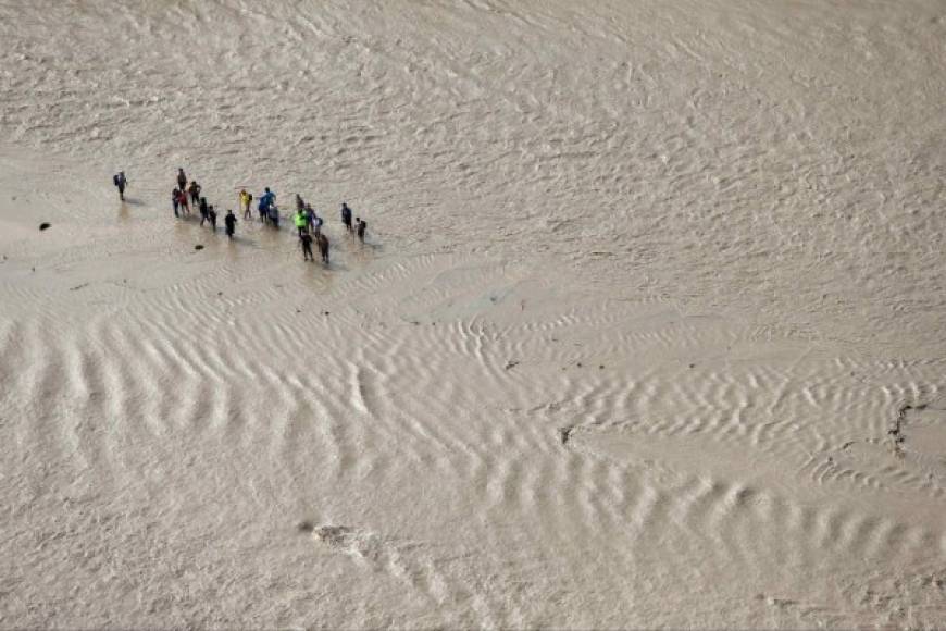 Esta fotografía aérea muestra a un grupo de pobladores pidiendo ayuda por encontrarse aislados debido a la crecida del río Virú, que arrasó varios puentes que comunicaban a diversos pueblos en la región norteña de La Libertad (Perú).