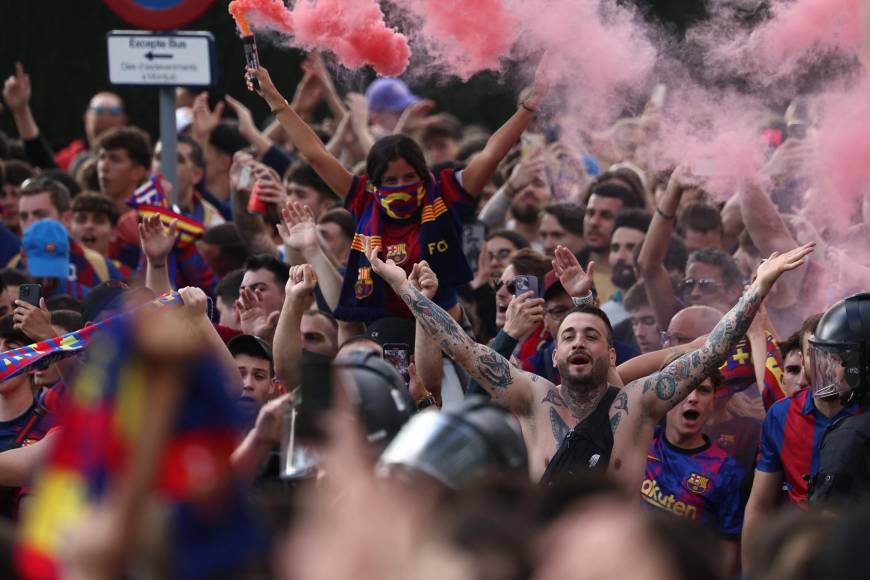 Los seguidores del Barcelona animan y encienden bengalas cuando llegan al estadio antes del partido.