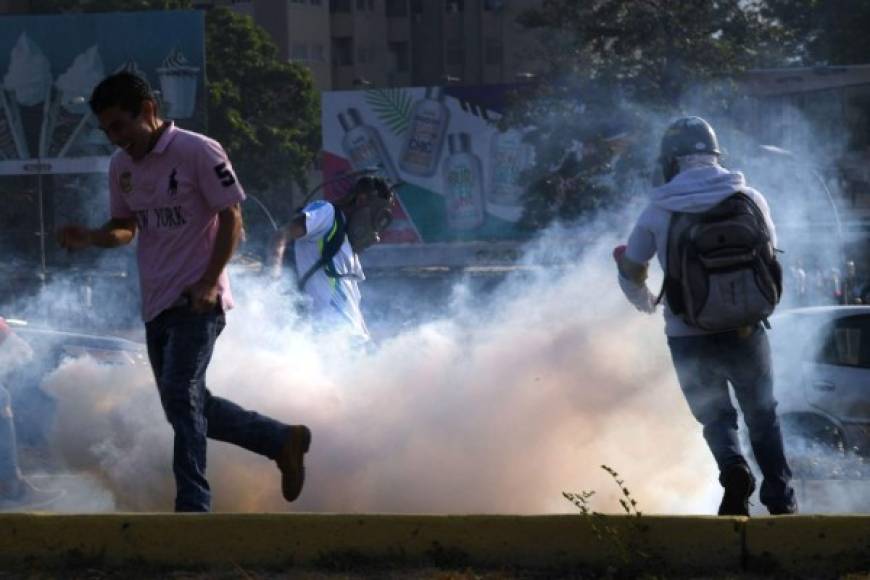Los manifestantes se enfrentan con piedras y bombas molotov a los militares que respaldan a Maduro y que responden con gases lacrimógenos y perdigones.