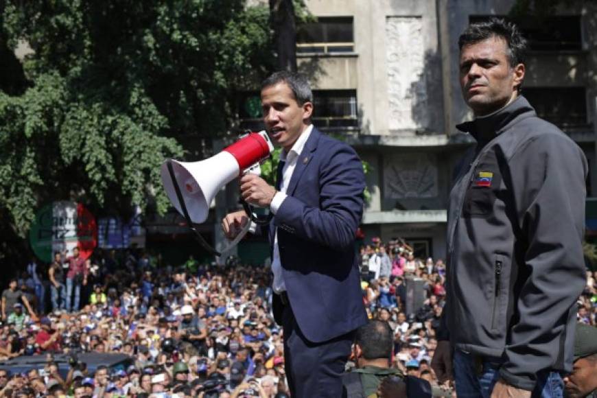 Venezuelan opposition leader and self-proclaimed acting president Juan Guaido (C) speaks to supporters next to high-profile opposition politician Leopoldo Lopez, who had been put under home arrest by Venezuelan President Nicolas Maduro's regime, and members of the Bolivarian National Guard who joined his campaign to oust Maduro, in Caracas on April 30, 2019. - Guaido -- accused by the government of attempting a coup Tuesday -- said there was 'no turning back' in his attempt to oust President Nicolas Maduro from power. (Photo by Cristian HERNANDEZ / AFP)