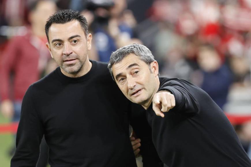 Ernesto Valverde parece señalarle algo a Xavi Hernández antes del partido.