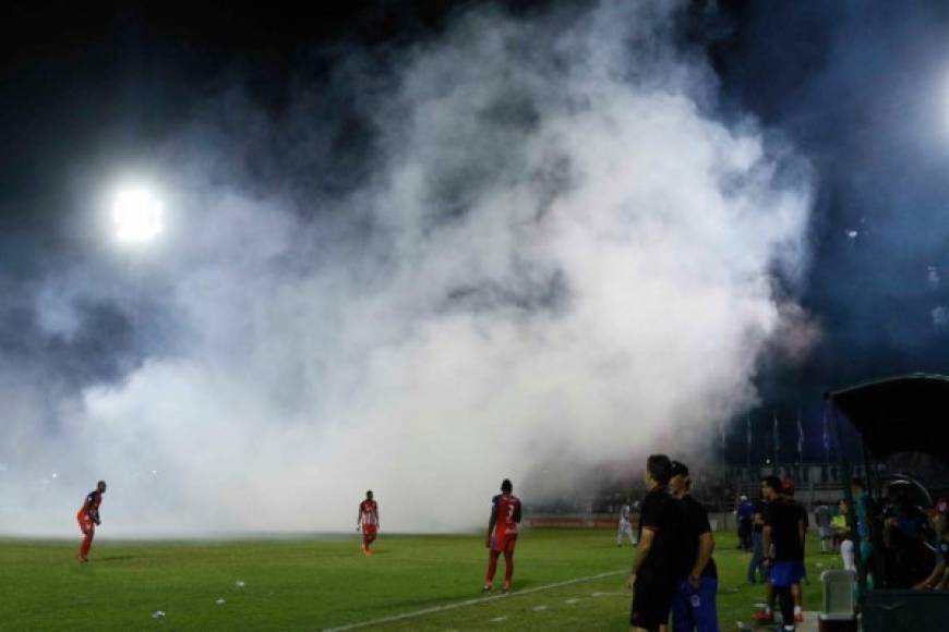 El humo de las bengalas cubrió el campo y el partido se detuvo unos minutos.