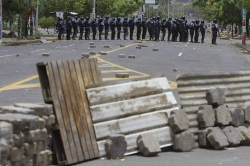 Policías despejaron a la fuerza las barricadas sobre la avenida principal, mientras civiles encapuchados y armados, conocidos como 'turbas', quitaban las barreras construidas en las calles adyacentes por pobladores para 'protegerse' de los grupos armados que operan por las noches.