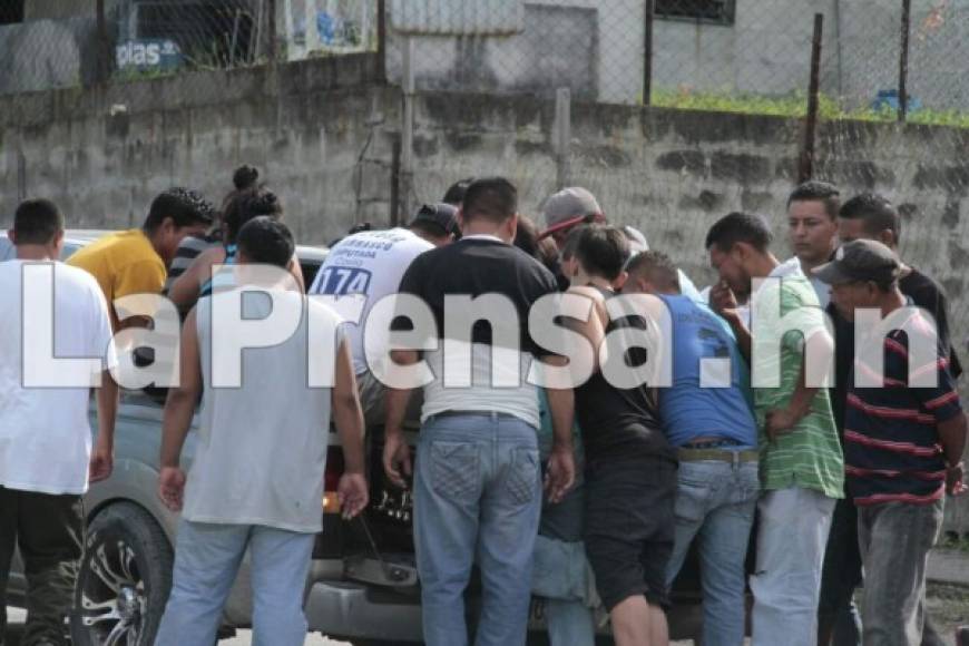 Familiares y amigos ayudan a bajar el ataúd de una de las víctimas del carro que lo transportó de la morgue a Choloma.