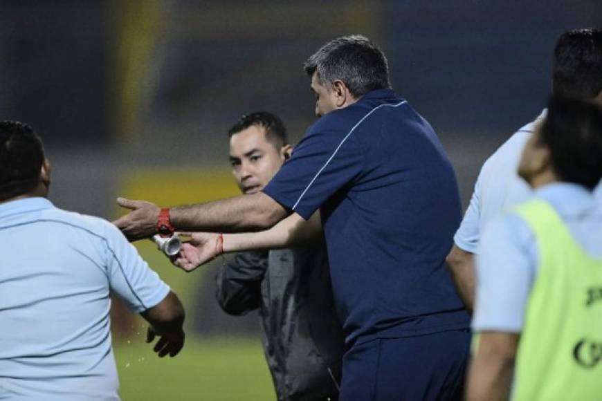 Diego Vázquez le muestra al cuarto árbitro Héctor Rodríguez una lata de cerveza que lanzaron al campo aficionados del Real España.