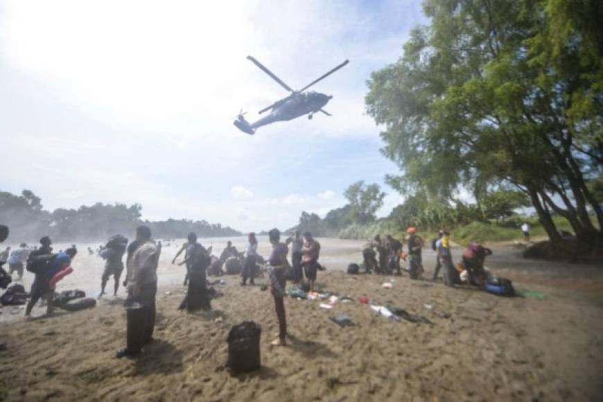 Un helicóptero de la policía federal mexicana intentaba persuadir a los migrantes a salir del rio Suchiate para impedir que llegaran a la otra orilla.