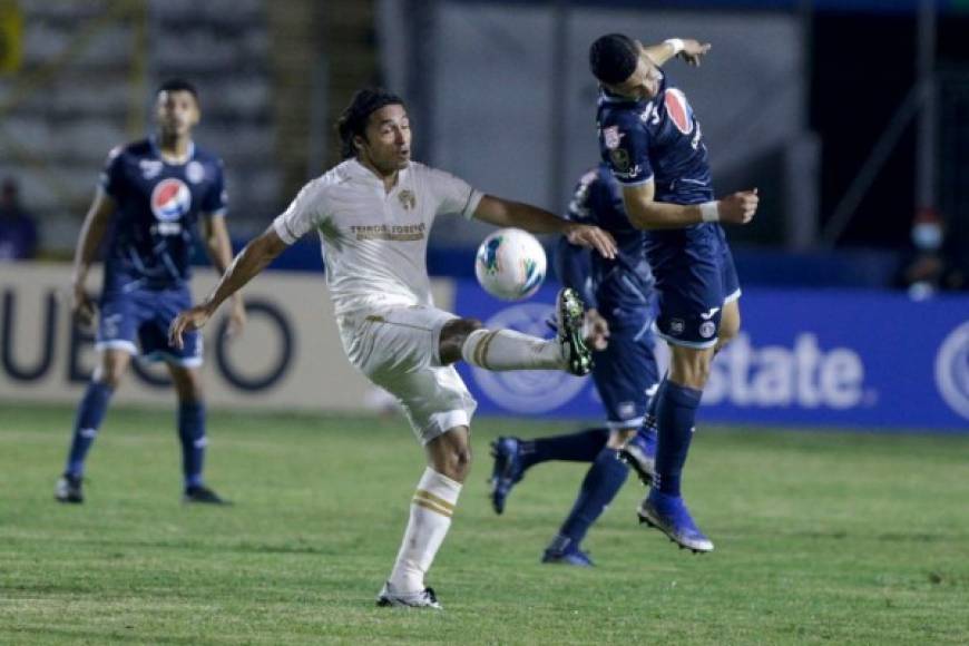 Héctor Castellanos intenta cabecear mientras el mexicano Agustín Herrera patea la pelota.