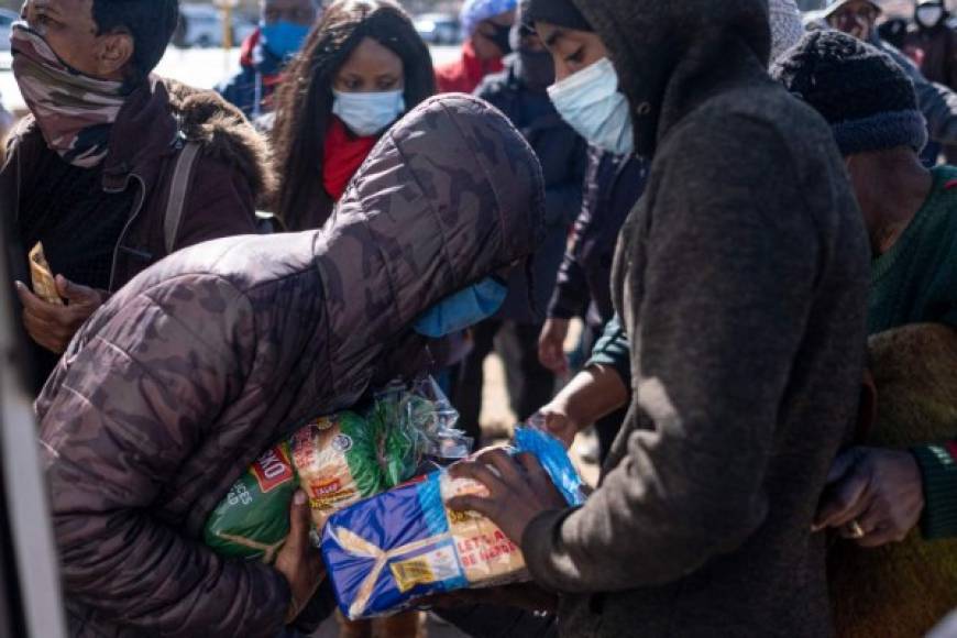 Imágenes de televisión mostraron a decenas de mujeres, hombres e incluso niños entrando a una carnicería de Soweto y saliendo con grandes cajas de carne congelada en sus hombros o cabezas.