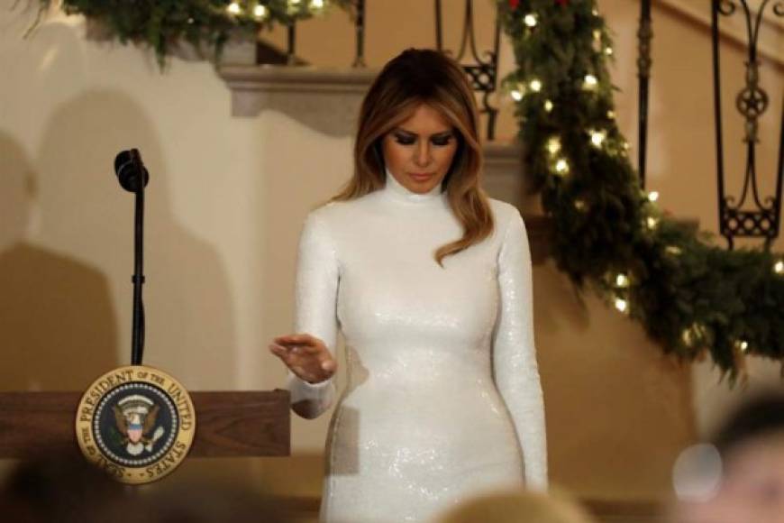 Melania deslumbró en la gala con un vestido de blanco de cuello cisne adornado con lentejuelas.