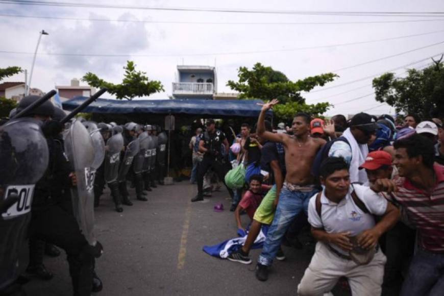 Guatemalan security forces try to prevent Honduran migrants from reaching the Guatemala-Mexico international border bridge in Ciudad Tecun Uman, Guatemala, on October 28, 2018. - A new group of Honduran migrants is trying to reach and cross the Guatemalan border into Mexico in the hope of eventually realizing the 'American dream' and reaching the United States. (Photo by SANTIAGO BILLY / AFP)