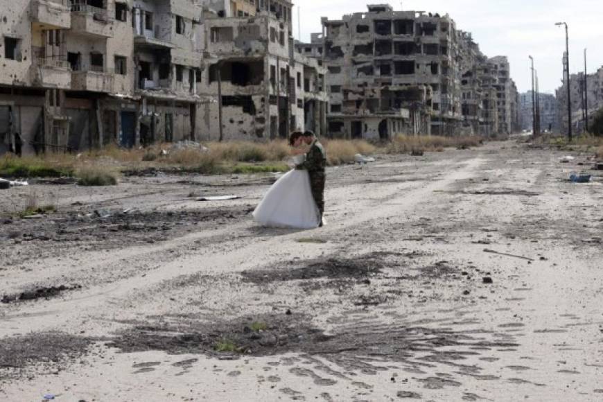 Una joven pareja conformada por un soldado del ejército sirio de Bachar al Assad y su novia, decidieron realizar las fotografías de su boda en los escombros de la ciudad siria de Homs. Fotos AFP.