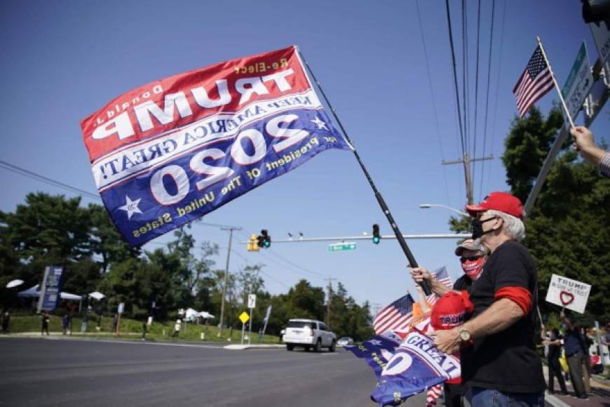 Supporters of US President Donald Trump hold signs and flags on October 4, 2020 outside of Walter Reed Medical Center in Bethesda, Maryland. - US President Donald Trump has 'continued to improve' as he is treated for Covid-19, his doctors said October 4, 2020, revealing he could be discharged as early as October 5, 2020. His medical team said his oxygen levels had dropped twice briefly in recent days and he is being treated with steroids, but they gave an upbeat assessment of the 74-year-old president's health and outlook. (Photo by ALEX EDELMAN / AFP)