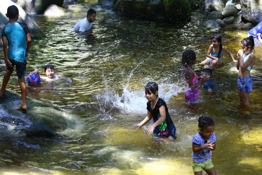 Un grupo de niños se divierten en el río Armenta de San Pedro Sula, las familias enteras sacan provecho para compartir en esta semana de feriado.