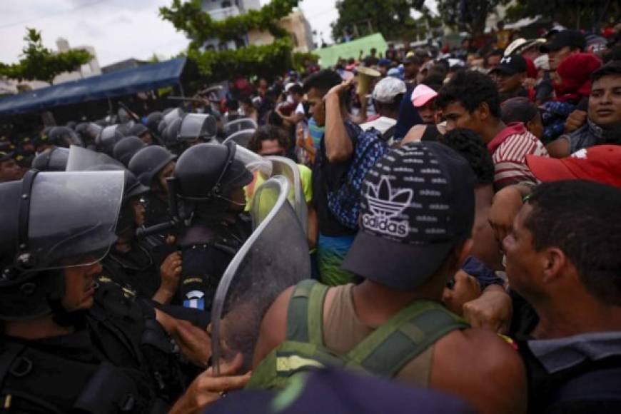 Guatemalan security forces try to prevent Honduran migrants from reaching the Guatemala-Mexico international border bridge in Ciudad Tecun Uman, Guatemala, on October 28, 2018. - A new group of Honduran migrants is trying to reach and cross the Guatemalan border into Mexico in the hope of eventually realizing the 'American dream' and reaching the United States. (Photo by SANTIAGO BILLY / AFP)