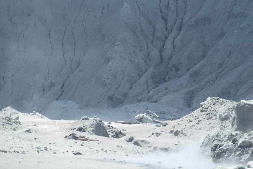 This handout photograph courtesy of Michael Schade shows wreckage of a helicopter amid ash minutes after the volcano on New Zealand's White Island erupted on December 9, 2019. - New Zealand police said at least one person was killed and more fatalities were likely, after an island volcano popular with tourists erupted on December 9 leaving dozens stranded. (Photo by Handout / Michael Schade / AFP) / RESTRICTED TO EDITORIAL USE - MANDATORY CREDIT 'AFP PHOTO / MICHAEL SCHADE' - NO MARKETING NO ADVERTISING CAMPAIGNS - DISTRIBUTED AS A SERVICE TO CLIENTS == NO ARCHIVE