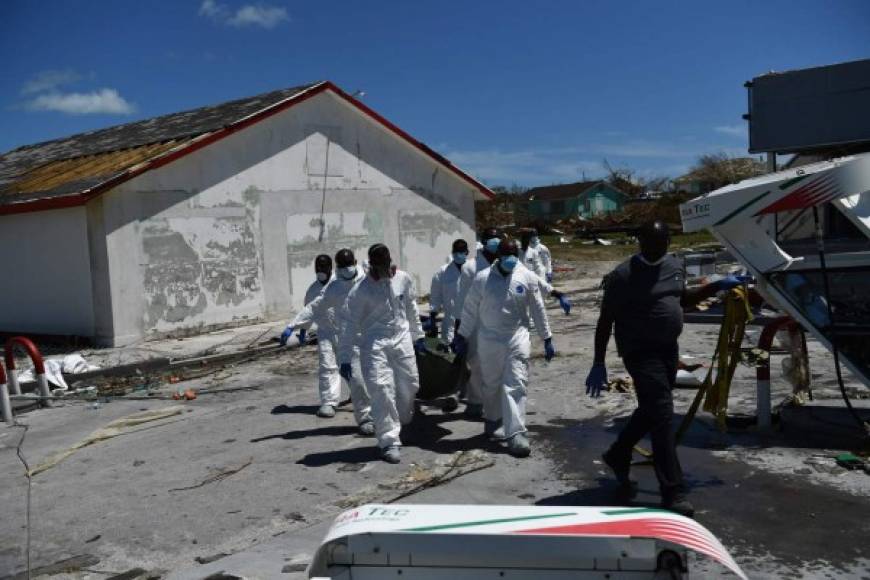 Rescue workers recover the body of a victim of Hurricane Dorian on September 5, 2019, in Marsh Harbour, Great Abaco Island in the Bahamas. - Hurricane Dorian lashed the Carolinas with driving rain and fierce winds as it neared the US east coast Thursday after devastating the Bahamas and killing at least 20 people. (Photo by Brendan Smialowski / AFP)