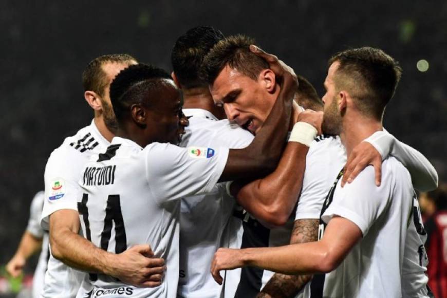 Mandzukic es felicitado por sus compañeros de la Juventus tras marcarle al Milan. Foto AFP