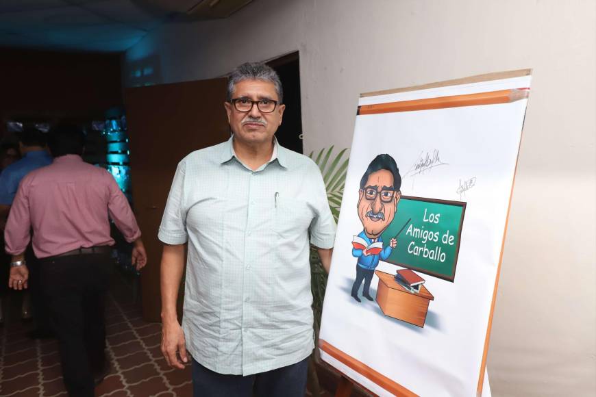 El profesro Carballo posando junto a la caricatura que le obsequiaron.