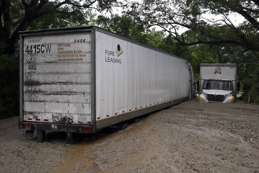 En un recorrido desde Puerto Vallarta hacia la zona de impacto en Nayarit, la AFP observó un deslave carretero que dejó prácticamente sepultado un trailer, provocando el cierre de la carretera.