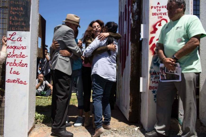 Members of the Fernandez Vargas family living on different sides of the US-Mexico border are briefly reunited during the 'Opening the Door of Hope' event at the border fence gate in Playas de Tijuana, Mexico on April 30, 2017. / AFP PHOTO / GUILLERMO ARIAS