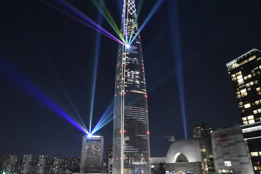 Las luces del haz se proyectan desde el rascacielos Lotte World Tower de 123 pisos durante un espectáculo de iluminación de cuenta regresiva para celebrar el Año Nuevo en Seúl el 1 de enero de 2022.