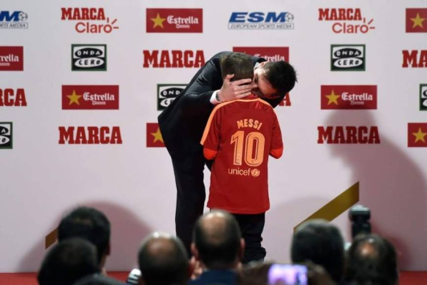 Messi besa a un niño después de recibir el trofeo Corazón de Oro por su trabajo benéfico antes de recibir la Bota de Oro.