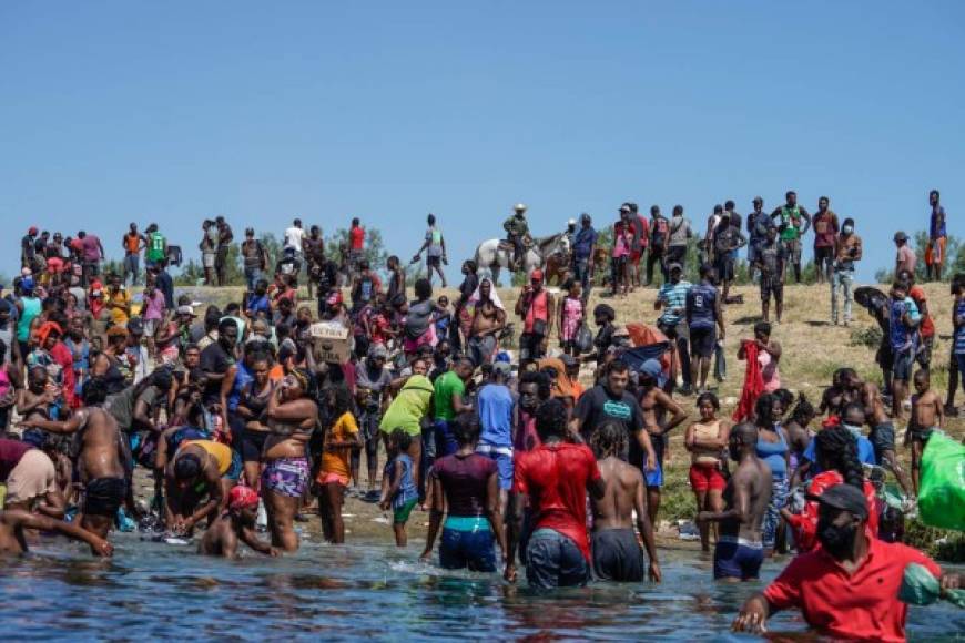 Haitian migrants, part of a group of over 10,000 people staying in an encampment on the US side of the border, cross the Rio Grande river to get food and water in Mexico, after another crossing point was closed near the Acuna Del Rio International Bridge in Del Rio, Texas on September 19, 2021. - The United States said Saturday it would ramp up deportation flights for thousands of migrants who flooded into the Texas border city of Del Rio, as authorities scramble to alleviate a burgeoning crisis for President Joe Biden's administration. (Photo by PAUL RATJE / AFP)
