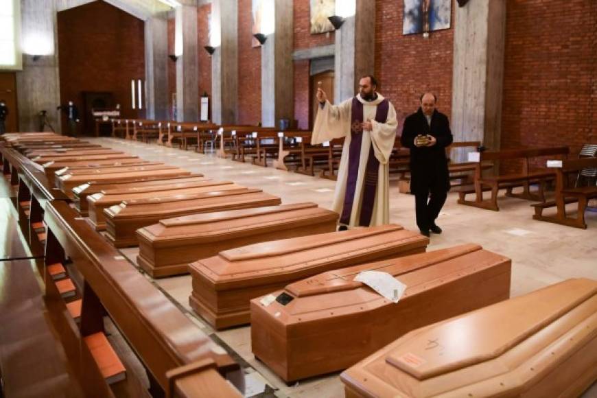 Ataúdes de personas fallecidas por el nuevo coronavirus son bendecidos antes de darle cristiana sepultura en Italia, donde sus familiares ni siquiera pueden darle el último adiós.