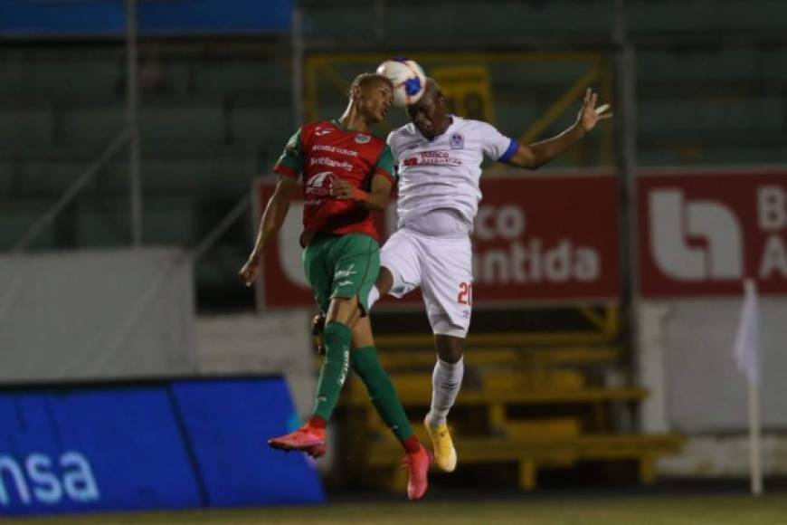Kervin Arriaga y Deiby Flores saltan por la disputa de la pelota.
