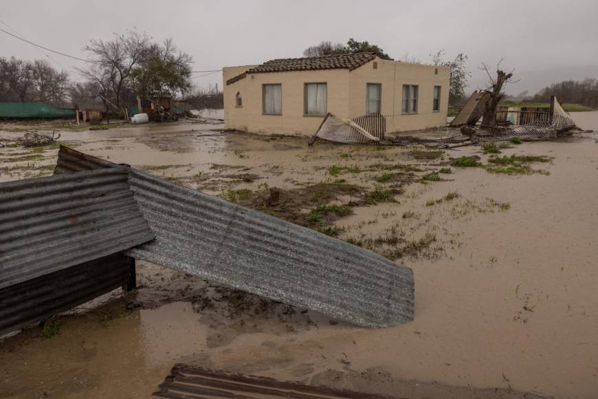 Flood waters inundate a home by the Salinas River near Chualar, California, on January 14, 2023, as a series of atmospheric river storms continue to cause widespread destruction across the state. - Parts of California braced Saturday for potentially disastrous flooding and snowfalls of up to six feet (two meters), as the latest in a damaging succession of storm systems barrels in over already water-drenched land. At least 19 people are known to have died as communities struggle to cope with the constant deluge. (Photo by DAVID MCNEW / AFP)