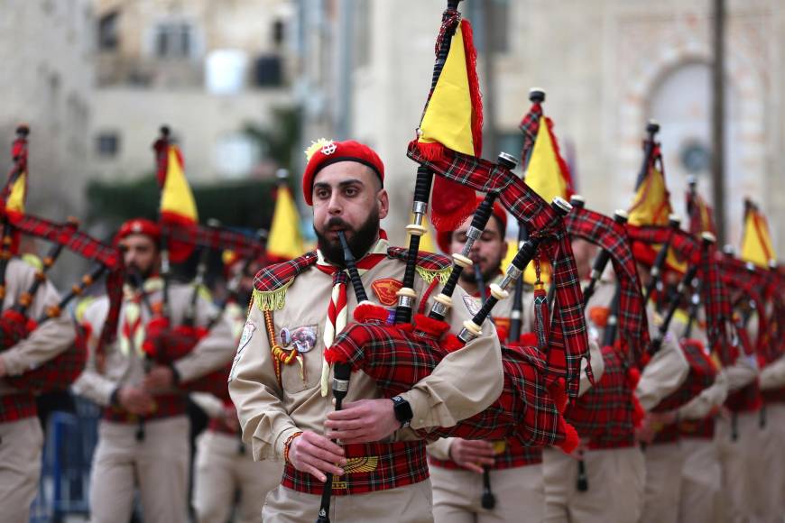 Los scouts, con sus boinas con pompón en la cabeza, efectuaron a las 9H00 locales su tradicional desfile en el casco histórico, bajo un cielo cubierto y el frío matinal. El sonido de los tambores y las gaitas trajo un poco de alegría a la plaza del Pesebre, junto a la Basílica de la Natividad.